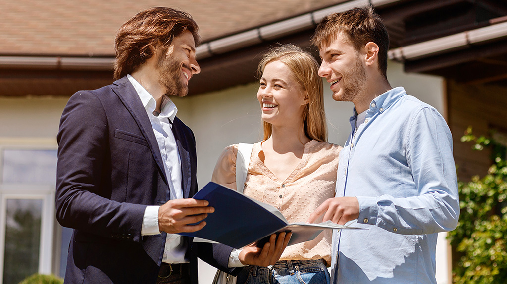 Realtor meeting with husband and wife prospects at an open house